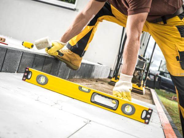 L'artisan carreleur Bordeaux en train de poser une terrasse en extérieur.