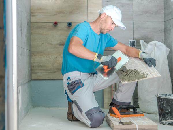 Un artisan carreleur à Bordeaux rénove une salle de bains.